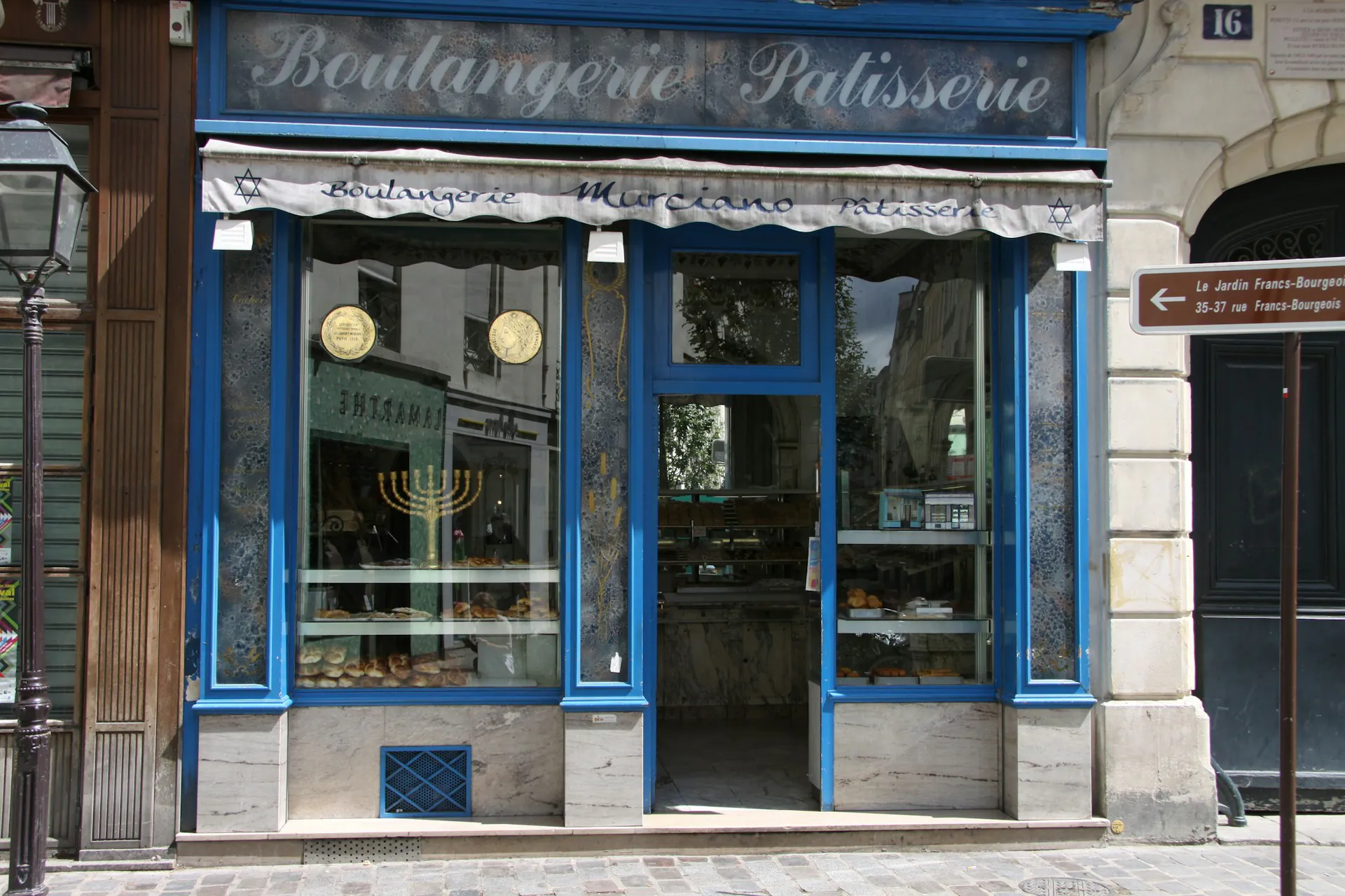 Jewish bakery storefront in Paris with menorah and Hebrew signs – a look into Jewish life in Le Marais, Paris.