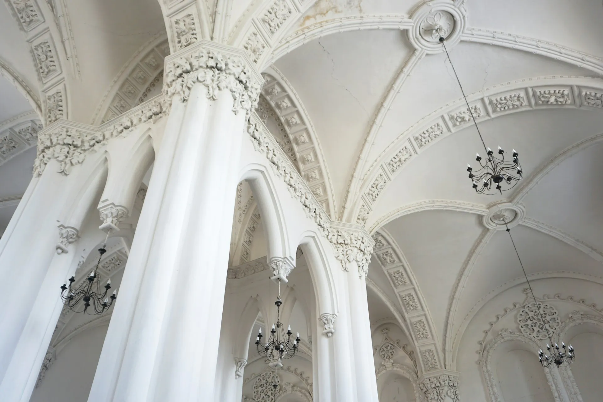 Ornate vaulted ceiling with chandeliers inside a historic synagogue visited on an England Jewish tour.