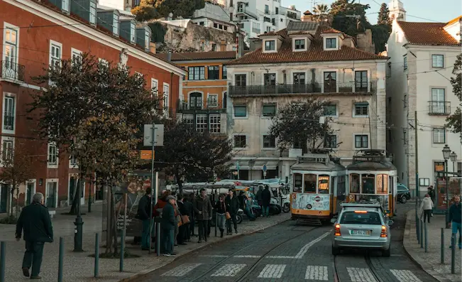 Travelers gather near the iconic Lisbon tram during a scenic stop on a Portugal Jewish heritage tour